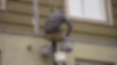 Arka plan bulanık. Yüksek irtifa işi. Adam yüksek binalarda çalışıyor.