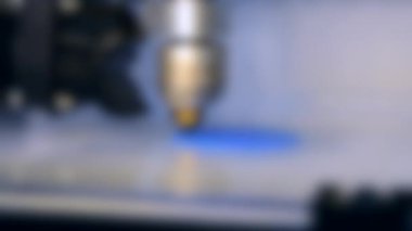 Arka plan bulanık. 3d yazıcı izole edilmiş mavi nesneyi yakın plan yazdırıyor