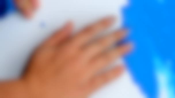 Fondo borroso. Revestimiento de pintura azul superficie blanca. Aplicar los dedos — Vídeos de Stock