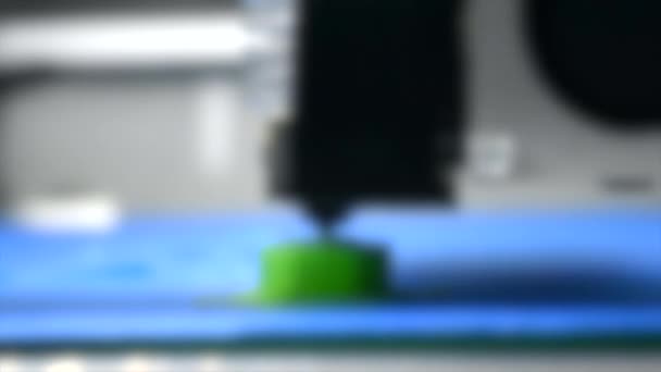 Fundo desfocado. Impressora 3D imprime forma verde de camadas de plástico close-up — Vídeo de Stock