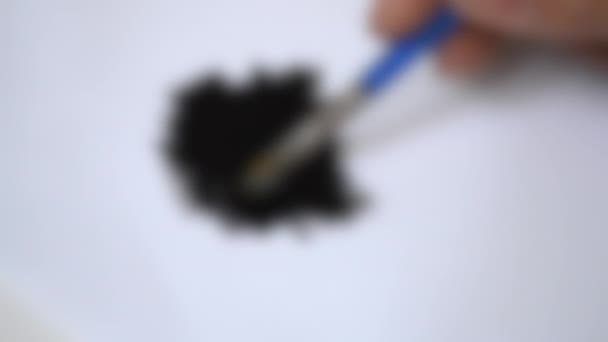 Unscharfer Hintergrund. Zeichnen mit Pinsel auf weißem Papier mit schwarzer Ölfarbe — Stockvideo