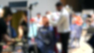 Arka plan bulanık. Erkek kuaförler erkek tıraşı oluyor.