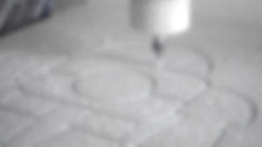 Arka plan bulanık. Değirmen makinesi beyaz bir yüzeye yakın çekim yapıyor.