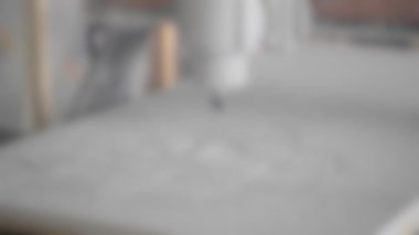 Arka plan bulanık. Değirmen makinesi beyaz bir yüzeye yakın çekim yapıyor.