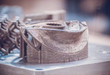 Adam metal 3D yazıcıya basılı nesne tutuyor. Nesne lazer sindirim makinesine basılmış. Metal tozundan modern 3D yazıcı baskısı. İlerici katkı maddesi DMLS, SLM, SLS 3D yazdırma teknolojisi