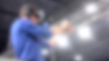 Arka plan bulanık. İnsan sanal gerçeklik miğferinde oyun oynar.