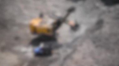 Arka plan bulanık. Granit ocağındaki farklı iş süreçleri ve makineler: