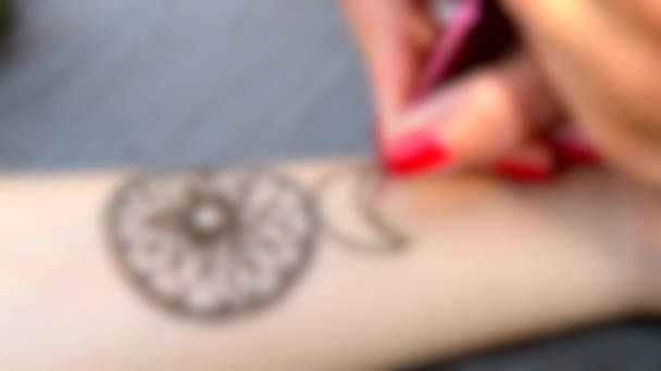 Unscharfer Hintergrund. Zeichnung mehendi Dreamcatcher auf einer Hand Nahaufnahme. — Stockvideo