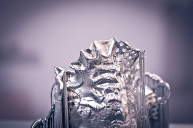 Metal 3D yazıcıya basılmış nesne. Lazer sinterleme makinesine basılmış diş kaplaması. Metal tozundan modern 3D yazıcı baskısı. Kavramsal katkı maddesi DMLS, SLM, SLS 3D yazdırma teknolojisi.