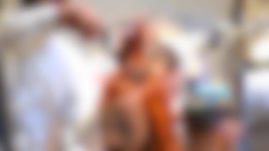 Arka plan bulanık. Erkek kuaförler erkek saçını yakından kesiyorlar.