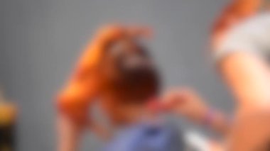 Arka plan bulanık. Kadın kuaförleri yakın plan kuaför kız modeli yapıyor.