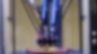 Arka plan bulanık. 3D yazıcı parlak sarı model yakın plan.