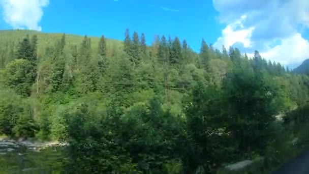 Vista desde la ventana del coche conduciendo por la carretera entre las montañas — Vídeos de Stock