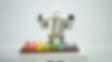 Arka plan bulanık. Küçük bir robot ksilofonda çalıyor. Yakından..