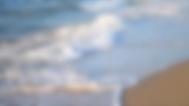 배경이 흐릿하다. 흰 거품이 일면서 모래로 돌진하는 푸른 물결 — 비디오