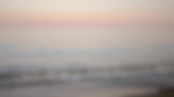 Rozmazané pozadí. Klidný večer u moře s růžovým a modrým horizontem — Stock video
