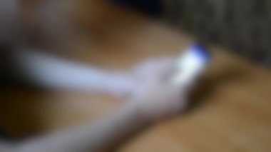 Arka plan bulanık. Erkekler telefon ve baş parmağıyla fotoğraflara bakarlar.