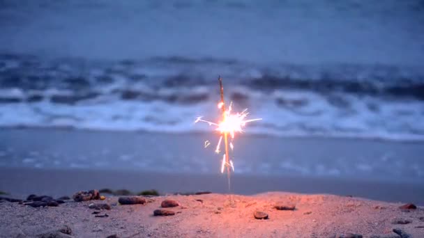 Bengalisches Feuer am Strand des Meeres in Nahaufnahme. Romantischer Urlaubshintergrund. — Stockvideo