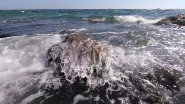 De golven van de zee lopen heel langzaam over de stenen aan de kust. — Stockvideo
