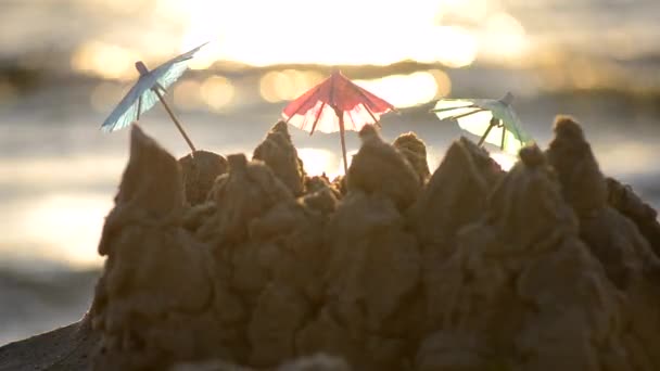 Three small beach umbrellas made of paper for cocktail stand in sand — Stock Video