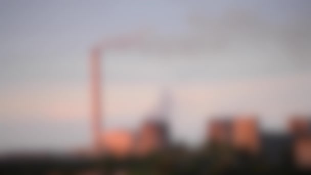 Wazige achtergrond. Pijpen thermische centrale met rook bij zonsondergang dageraad licht — Stockvideo