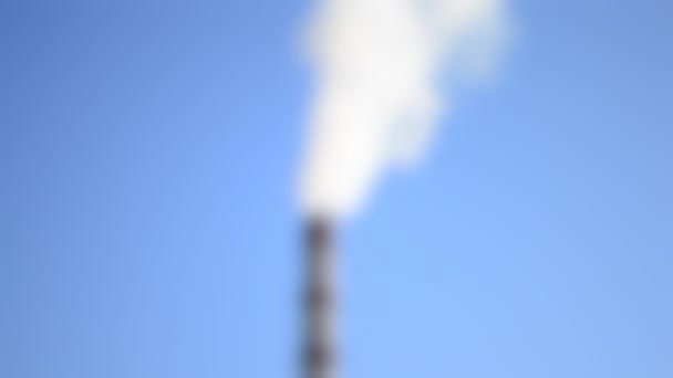 Размытое прошлое. Высокий дымоход с приходящим дымом фоне голубого неба Timelapse — стоковое видео