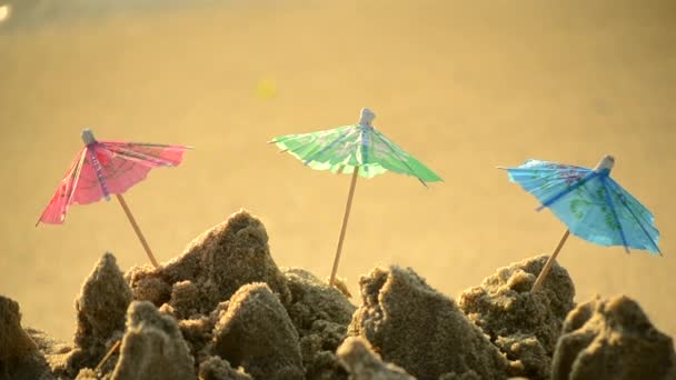 Kis strand esernyők papírból készült egy koktél stand a homokos strandon — Stock videók