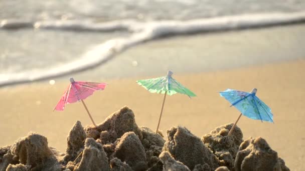 Små strandparaplyer av papper för ett cocktailställ på sandstranden — Stockvideo