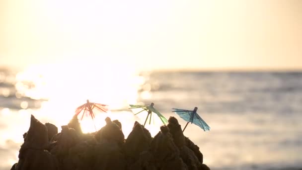 Små strandparaplyer av papper för ett cocktailställ på sandstranden — Stockvideo