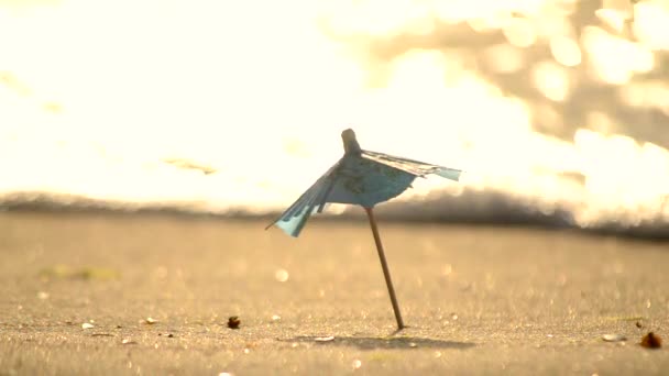 Ein kleiner Sonnenschirm aus Papier für einen Cocktailstand im Sandstrand — Stockvideo