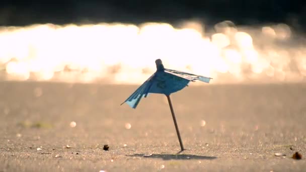 Um guarda-sóis de praia pequeno feito de papel para um coquetel na praia de areia — Vídeo de Stock