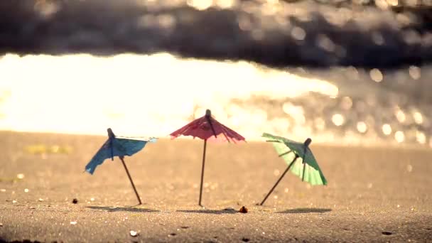 Små strandparaplyer av papper för ett cocktailställ på sandstranden — Stockvideo