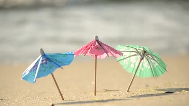Kumsaldaki bir kokteyl standı için kağıttan yapılmış küçük plaj şemsiyeleri. — Stok video