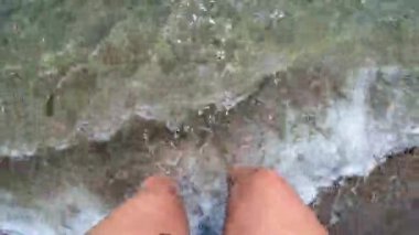 Kumsalda yürüyen bir kız kumlu ve kabuklu.