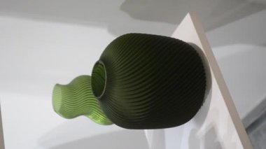 Nesne 3D yazıcıya yazıldı. Kapatın. Erimiş plastikten 3D yazıcıya basılmış bir model. Vazo 3 boyutlu yazıcıya erimiş plastik yeşil renkten basılmış. 3D baskı. Katkı sağlayan FDM teknolojileri. Dikey