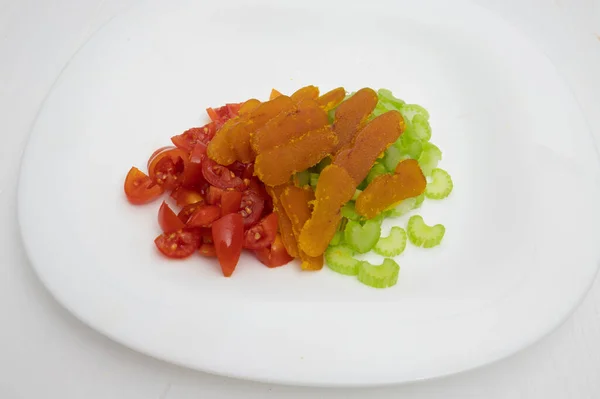 plate of salad with cherry tomatoes and bottarga, a type of Sardinian cuisine