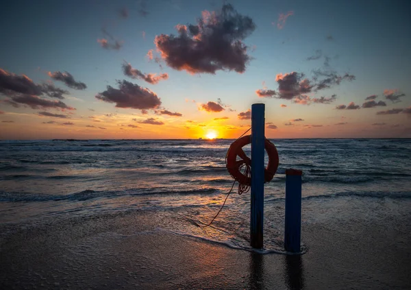 sunset on the shore with objects for the rescue of bathers