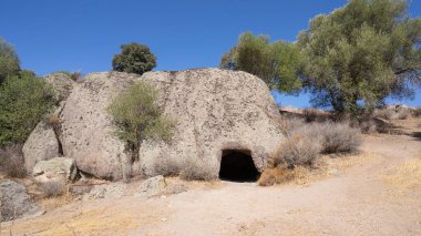 Sardunya 'da doğal kemer şekilli girişi olan kayaya oyulmuş tarih öncesi oda mezarı.