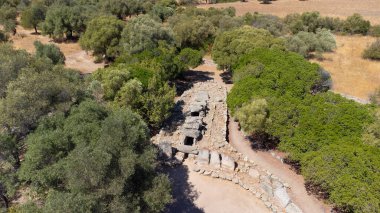Olbia yakınlarında ağaçlar ve kuru manzarayla çevrili tarih öncesi dev mezarları.