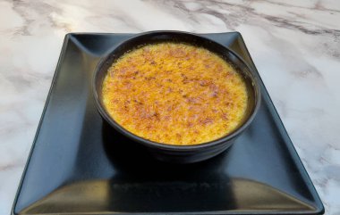 Kare tabakta siyah seramik kasede karamelize Katalan kremalı tatlı