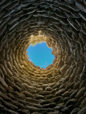 Sardunya Nuraghe 'nin iç perspektifi gökyüzüne doğru gömülü taş kasa yapısını gösteriyor