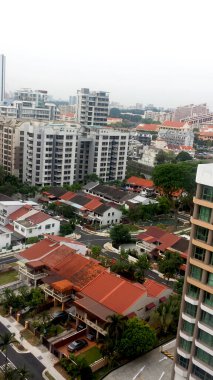 Büyük modern binanın havadan görünüşü ve Singapur şehrinin mavi gökyüzü.