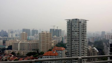 Büyük modern binanın havadan görünüşü ve Singapur şehrinin mavi gökyüzü.