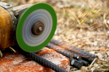 Demir kesme makinesinin yardımıyla demir yolu kesen adam altından köpükler çıkartıyor.