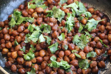 Hindistan nohut tabağı (chana masala) üzerinde kişniş laves garnitür ile
