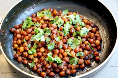 Hindistan nohut tabağı (chana masala) üzerinde kişniş laves garnitür ile