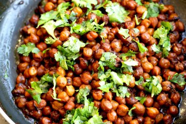 Hindistan nohut tabağı (chana masala) üzerinde kişniş laves garnitür ile
