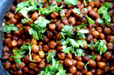 Hindistan nohut tabağı (chana masala) üzerinde kişniş laves garnitür ile