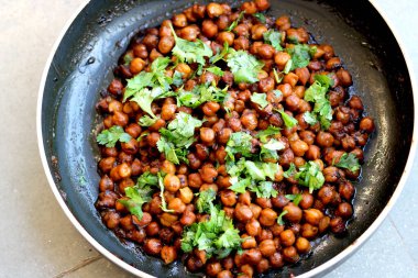 Hindistan nohut tabağı (chana masala) üzerinde kişniş laves garnitür ile