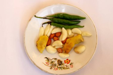 Hindistan çiğ baharatlı biber, sarımsak, zencefil ve beyaz tabakta yer fıstığı.